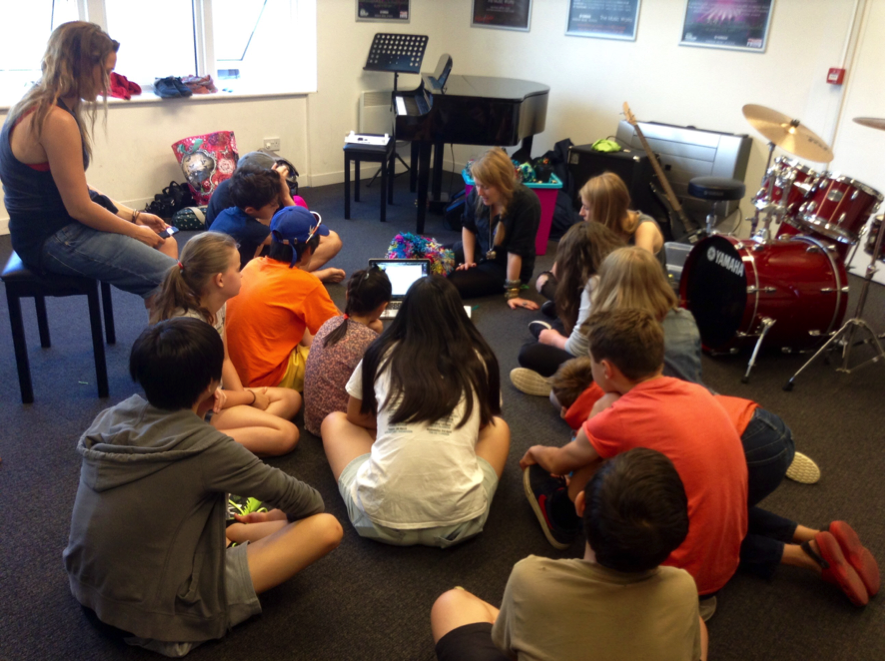 An image of Sam sharing the pompom's inner workings to a group of young music technologists.